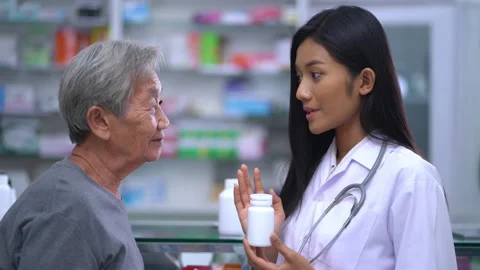 Pharmacist assisting explaining medicine to Old patient customers in pharmacy Video stock 136940275