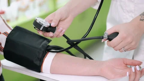 Pharmacist checking blood pressure of customer Stock Footage 141500664