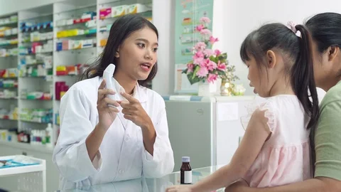 Pharmacist checking patient body temperature by digital thermometer Stock Footage 108646392