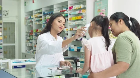 Pharmacist checking patient body temperature by digital thermometer Stock Footage 108646414