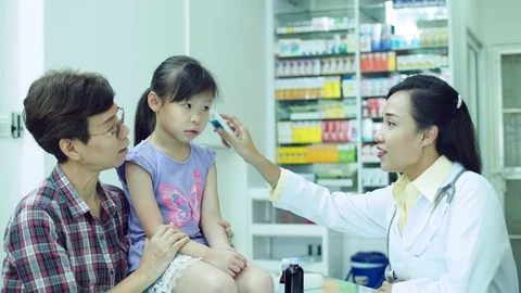 Pharmacist checking patient body temperature by digital thermometer Stock Footage 113976455