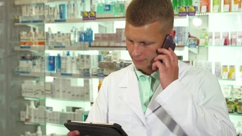Pharmacist consulting a patient while answering the phone Stock Footage 311982689