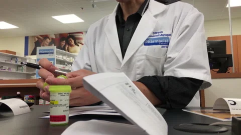 Pharmacist explaining a prescription to a customer inside a Walmart store Video stock 228912578