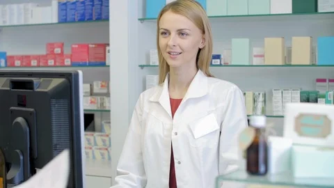 Pharmacist Filling Prescription and Talking to Customer at Pharmacy Counter Stock Footage