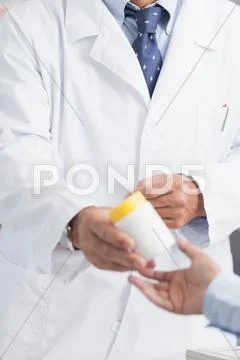 Pharmacist giving a box of pills to someone Stock Photos