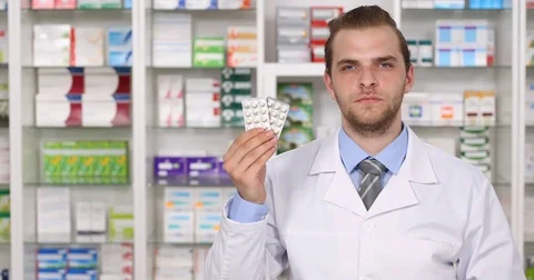 Pharmacist Man Holding Tablet Pills Showing Thumb Up Sign in Pharmacy Shop Store Video stock 80249153