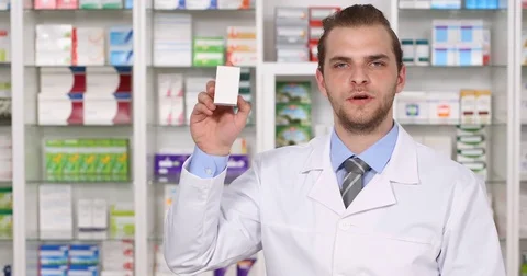 Pharmacist Man Talking and Showing a Drug Box Medicine Description Pharmacy Shop Video stock 73553434