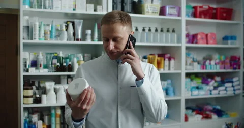 A pharmacist at a pharmacy advises a client by phone. Telephone call. Stock Footage 144284835