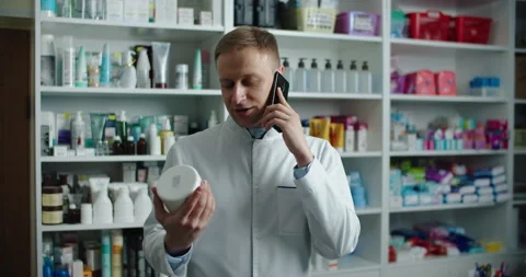 A pharmacist at a pharmacy advises a client by phone. Telephone call. Stock Footage 144351054