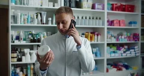 A pharmacist at a pharmacy advises a client by phone. Telephone call. Stock Footage 144735115