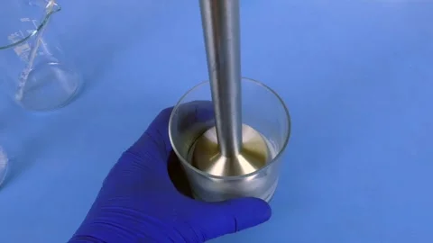 Pharmacist preparing a pharmaceutical emulsion in the laboratory with an Stock Footage 335179284