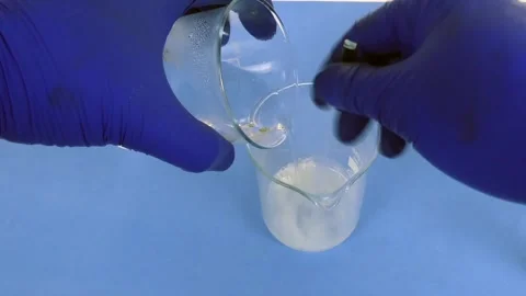 Pharmacist preparing a pharmaceutical emulsion in a laboratory by mixing 库存影片 335179461
