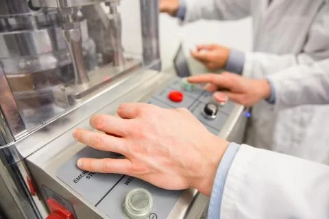 Pharmacist pressing button on machine Stock Photos