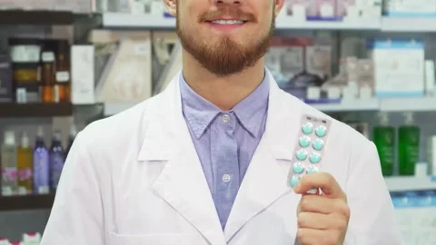 Pharmacist proudly displays pills while giving a thumbs up Stock Footage 311992884