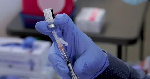 Pharmacist pulls COVID-19 vaccine into syringe Stock-Footage 148484385