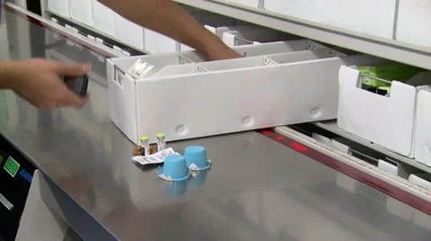 Pharmacist pulls out a medication drawer and scans perscriptions Stock Footage 50633933