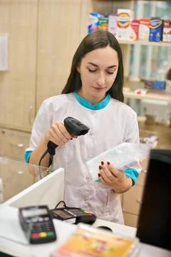Pharmacist scans barcode in pharmacy setting Stock Photos