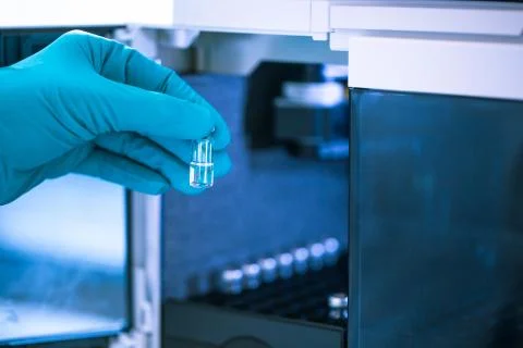 Pharmacist, scientist inserts some samples for chromatographic testing, pharmacy 库存照片