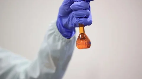 Pharmacist shaking a drug mixture in a beaker in lab. Stock Footage 304849919