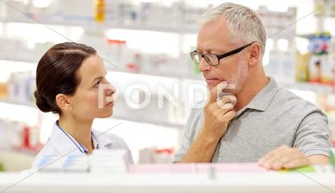 Pharmacist showing drug to senior man at pharmacy Stock Photos