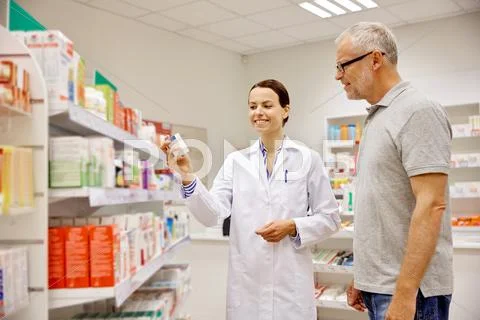 Pharmacist showing drug to senior man at pharmacy Stock Photos