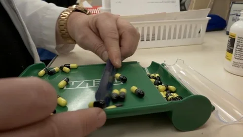 Pharmacist sliding pills into container Video stock 108506360