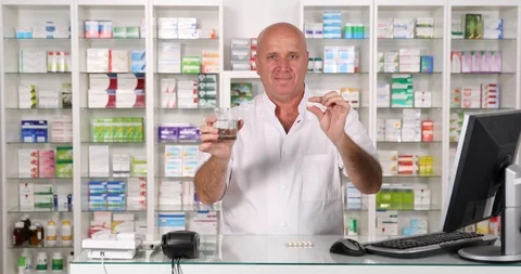 Pharmacist Smile and Keep in Hand one Medical Pill and a Glass with Water 스톡 동영상 109121114