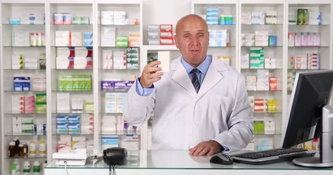 Pharmacist Smiling Presenting and Recommending Medical Pills in a Pharmacy Stock Footage 103257544