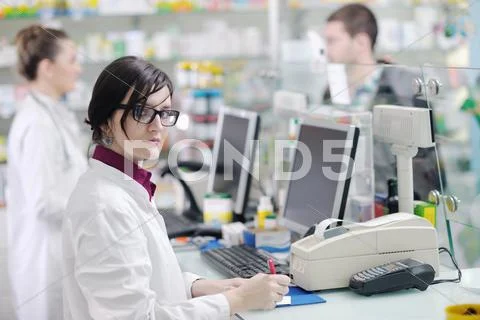 Pharmacist suggesting medical drug to buyer in pharmacy drugstore Stock Photos