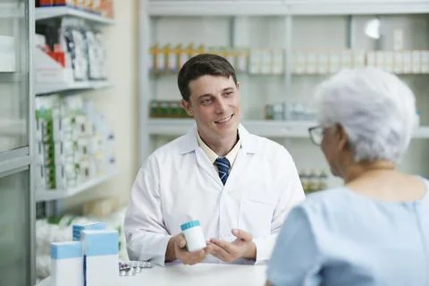 Pharmacist talking to a client about prescribed medications. Foto stock