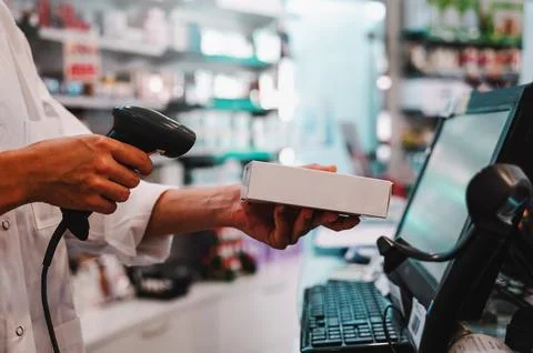 Pharmacist uses barcode reader to identify and sell a drug Stock Photos