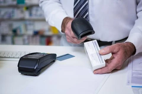 Pharmacist using barcode scanner on medicine box in pharmacy Stock Photos