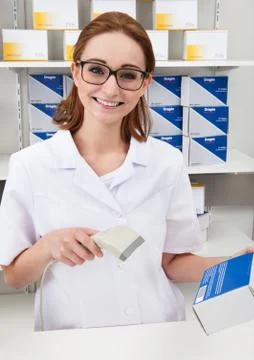 Pharmacist using scanner in drugstore Photos