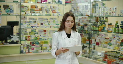 Pharmacist using tablet pc at the pharmacy checks for medication Stock Footage 170987840