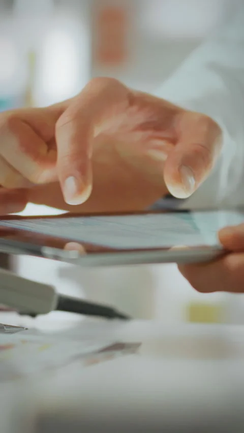 Pharmacist utilizes tablet to manage prescriptions in a pharmaceutical setti Stock Footage 331677110