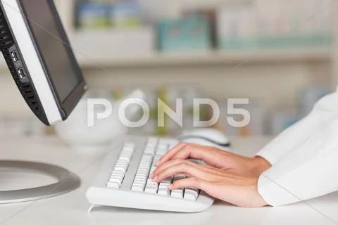 Pharmacist's hands typing on computer keyboard Stock Photos