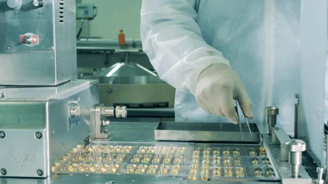 Pharmacologist using tweezers to sort pills of fish oil. Pharmaceutical industry Stock Footage 140899284