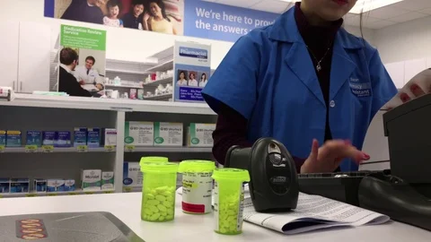 Pharmacy assistant counting price for customer prescription medicine Stock Footage 72232775