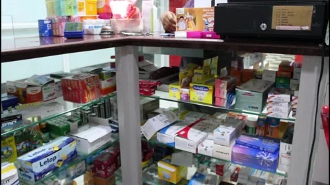 Pharmacy assistant is handling over the counter medicine Stock Footage 345995381