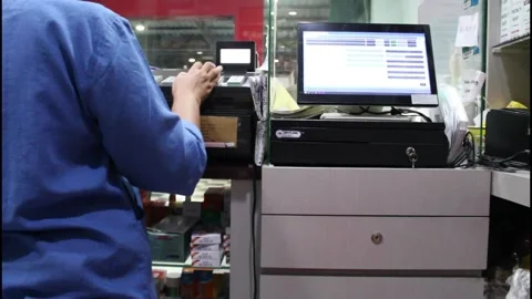 Pharmacy assistant manually entering medicines prices into cash register machine Stock Footage 345999460