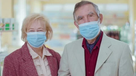 In the pharmacy elderly couple look at camera with medical mask. Feel headache Stock Footage 140763748