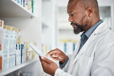 Pharmacy, medicine and black man with tablet to check inventory, stock and Stock Photos
