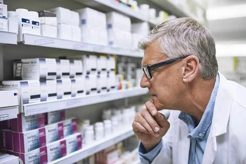 Pharmacy, medicine and thinking with man at shelf in drug store for search Stock Photos