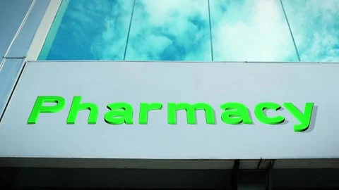 Pharmacy Sign on Modern Building with Cloud Reflection on Windows Glass Stock Footage 303564493