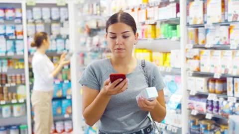 In pharmacy visitor scan QR Code and reads composition of cream for problematic Video stock 242972293