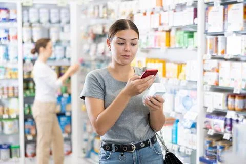 In pharmacy visitor scan QR Code and reads composition of cream for problematic Foto stock