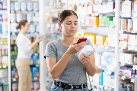 In pharmacy visitor scan QR Code and reads composition of cream for problematic Stockfoto's