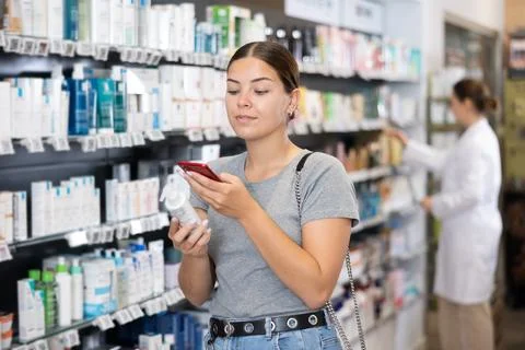 In pharmacy visitor scan QR Code and reads composition of cream for problematic Foto stock