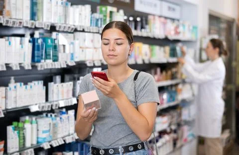 In pharmacy visitor scan QR Code and reads composition of cream for problematic Stockfoto's