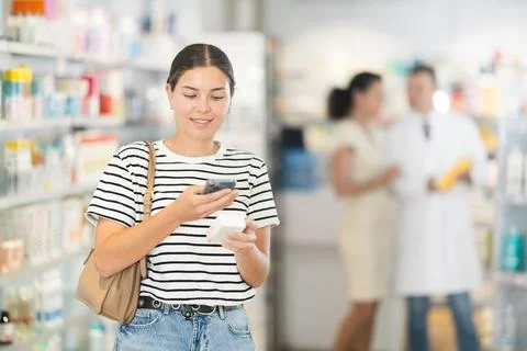 Pharmacy visitor scans a QR code and reads the composition of the medicine on 写真素材